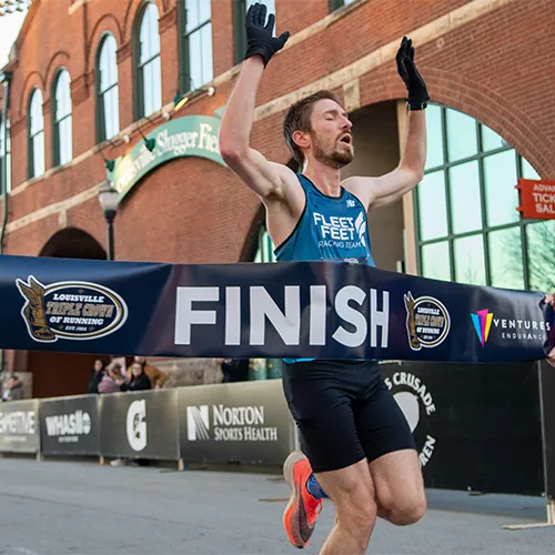 man crossing finish line