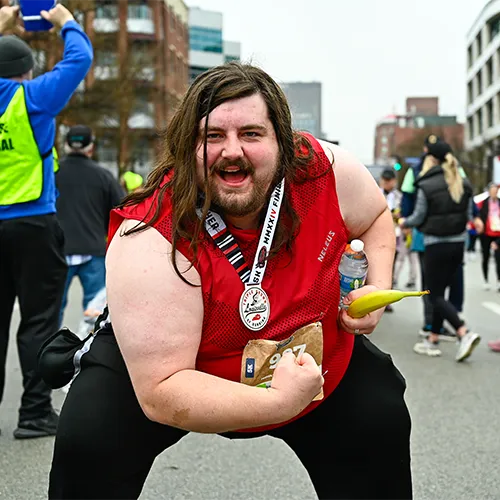 man with medal showing off muscles