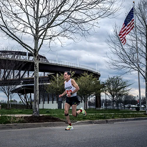 man running with American flag in background