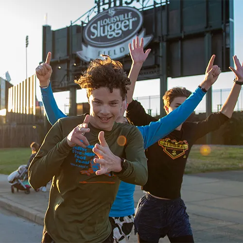 teenagers running near Louisville Slugger Field